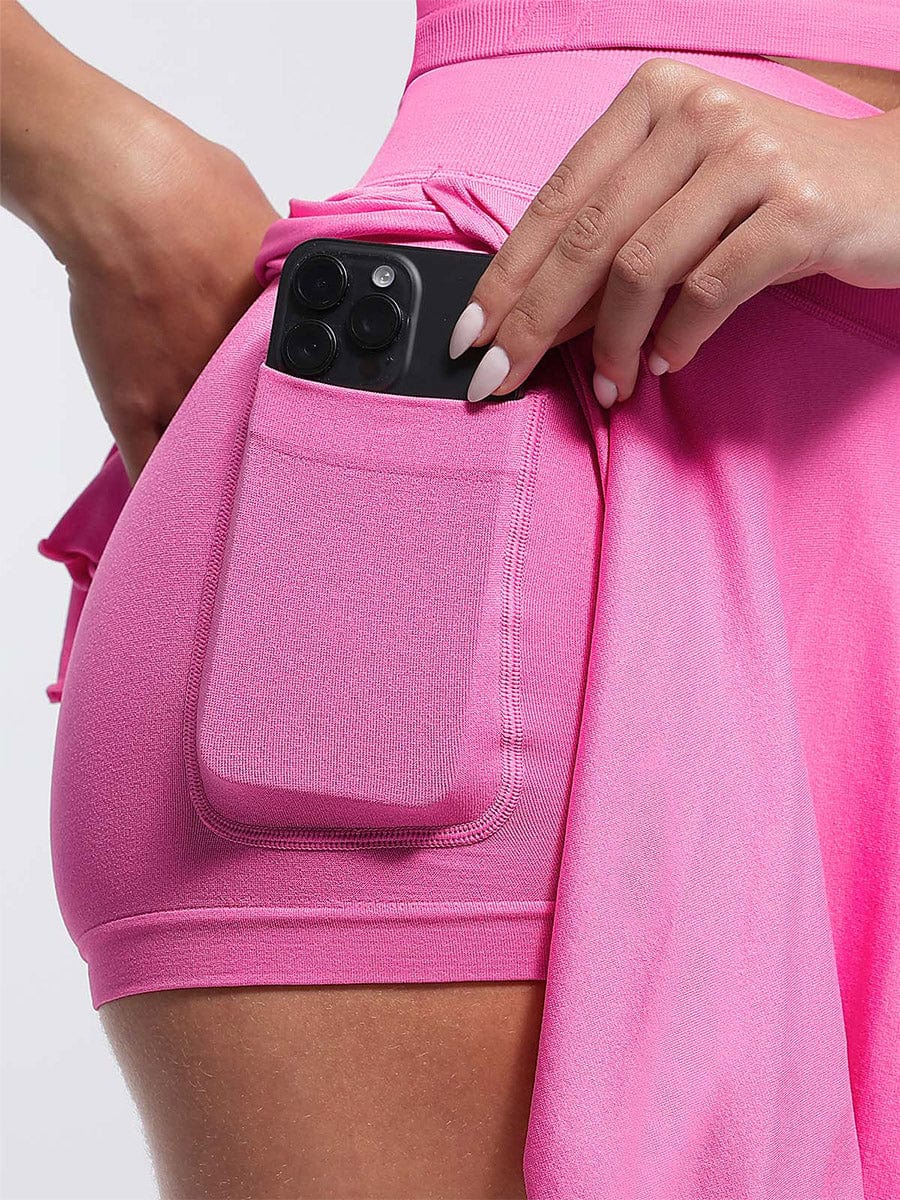 Falda acampanada con cintura media, corte A, bajo con volantes, pantalones cortos y bolsillos incorporados.