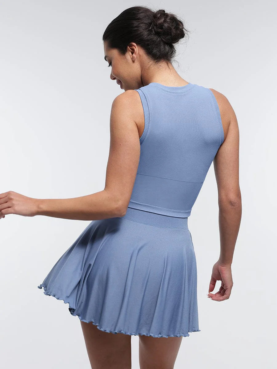 Falda acampanada con cintura media, corte A, bajo con volantes, pantalones cortos y bolsillos incorporados.